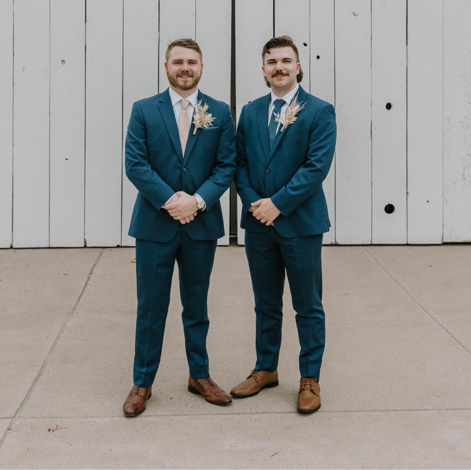 Tanner Ensign (right) and Cooper Ensign (left) dressed in suits taking a picture together